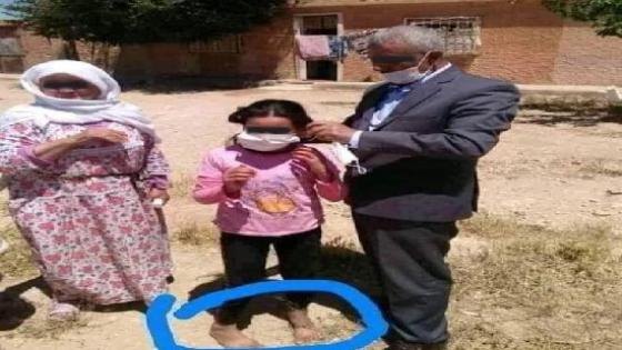 صورة مسؤول يضع كمامة لطفلة حافية القدمين تلهب مواقع التواصل الاجتماعي وسط انتقادات واسعة